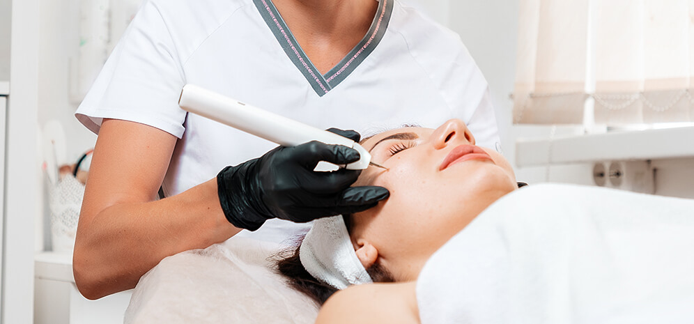 Frau wird in einer Hautarztpraxis vom Hautarzt im Gesicht behandelt - Swift Warzenbehandlung – MVZ Die HautTypen GmbH, Breisach